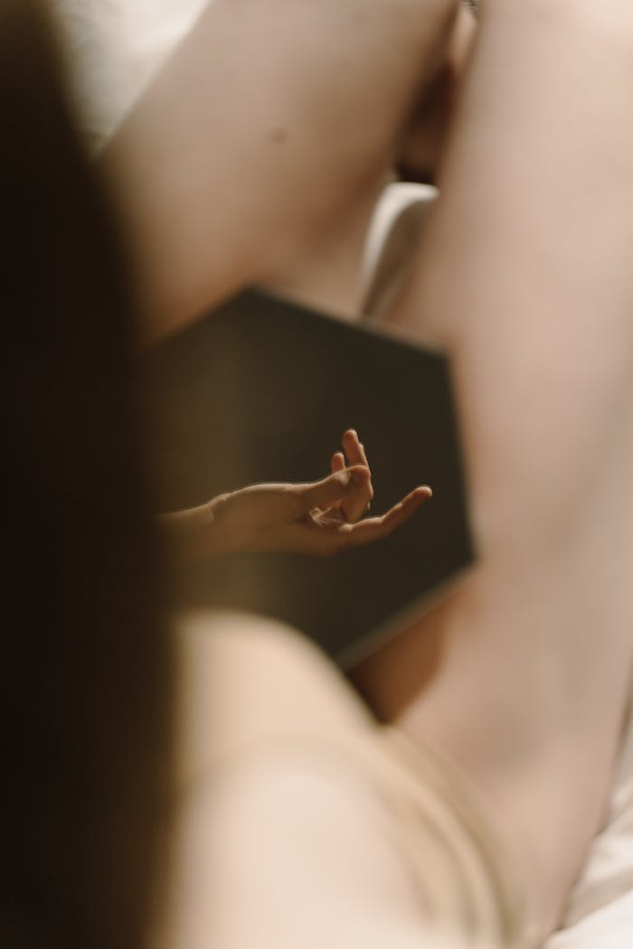 Soft focus on a hand's reflection in an intimate and elegant nude setting.